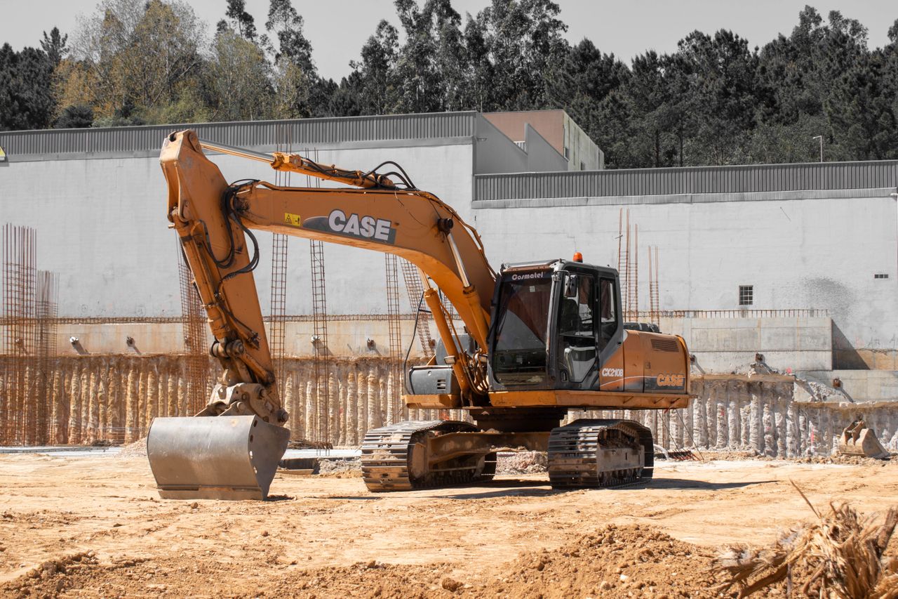 A large excavator positioned at an active construction site with clear skies.